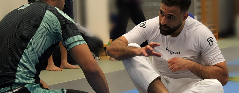 Session d(apprentissage du Jiu-JItsu Un coach de Jiu-Jitsu brésilien expliquant des techniques de combat à un élève attentif lors d’une session d’entraînement.